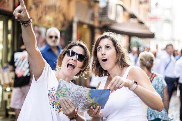 Foto amiche che fanno gesti in piedi sulla strada