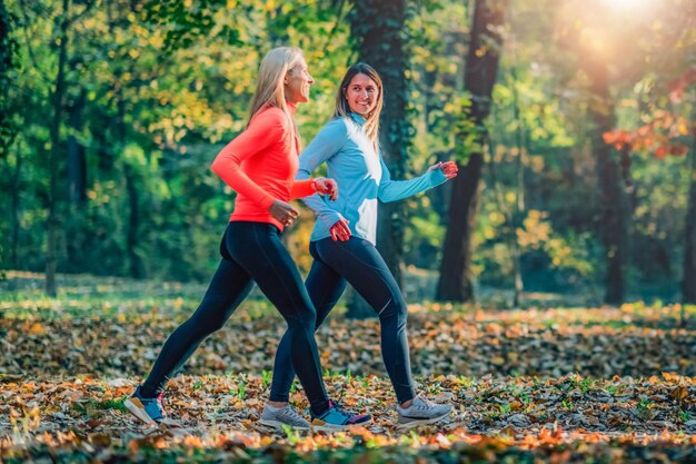 Female Friends Jogging in Public Park Autumn Fall