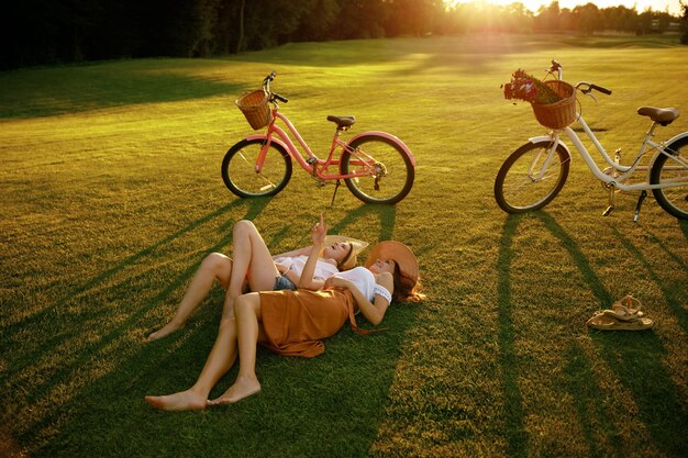 Female friends sitting on grass laughing and talking