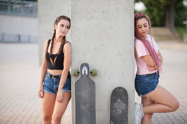 Photo female friends standing by column