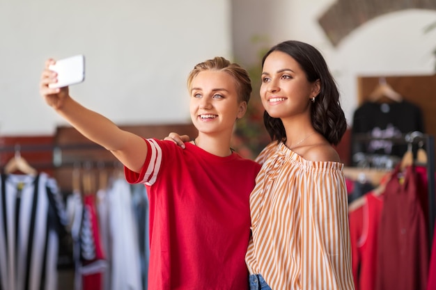 Foto amiche che si fanno un selfie al negozio di abbigliamento