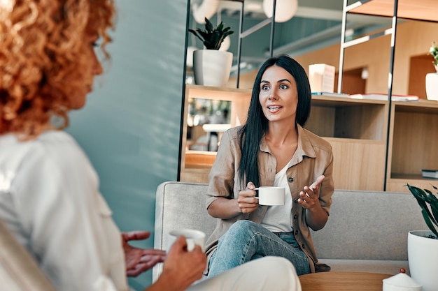 Female friends talking break between work for coffee cheerful\
businesswoman discussing business plans in cafe