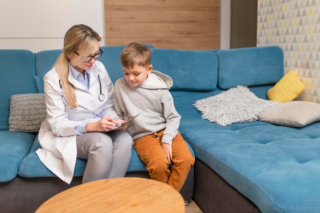 Photo female friends using phone while sitting on sofa at home