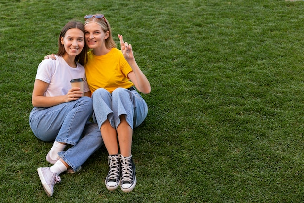 Foto amici femminili che utilizzano il linguaggio dei segni all'aperto con lo spazio della copia