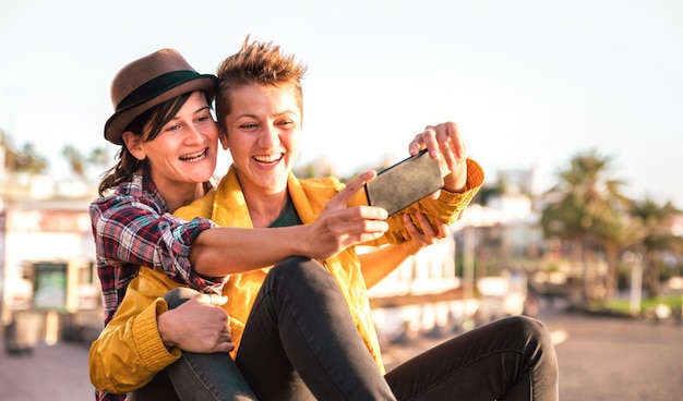 Il concetto femminile di amicizia con le ragazze coppia la presa del selfie all'aperto in tenerife