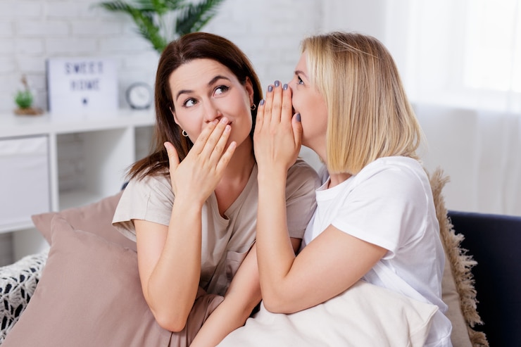 Photo female friendship, gossip and secrets - portrait of two happy young women whispering in cozy living room at home