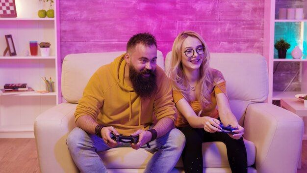 Premium Photo  Boyfriend cheering her beautiul girlfriend while she's playing  online games using wireless controller. room with neon light.