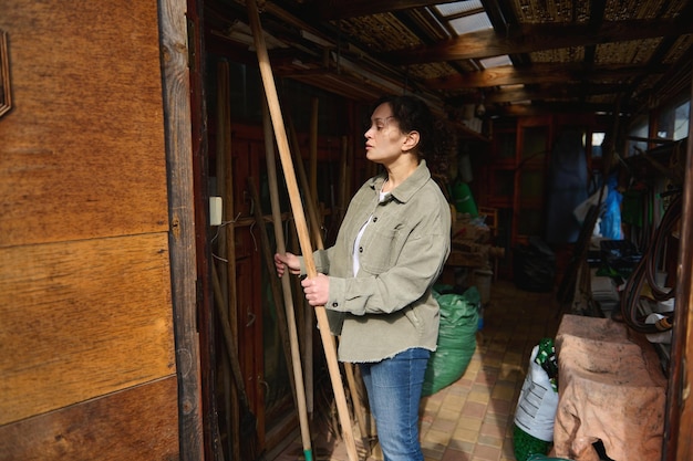 Female gardener choosing gardening tools standing in her workshop full of instruments seeds and soil in package Horticulture agriculture home gardening leisure and hobby