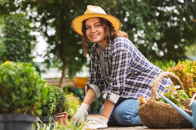 Photo female gardener with water can working near flowers in greenhouse