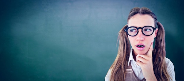 Female geeky hipster looking confused against green chalkboard