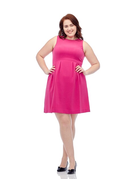 female, gender, portrait and people concept - smiling happy young plus size woman posing in pink dress