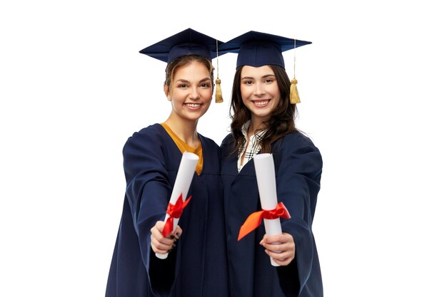 female graduates in mortar boards with diplomas