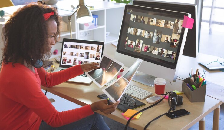 Photo female graphic designer looking photographs at desk