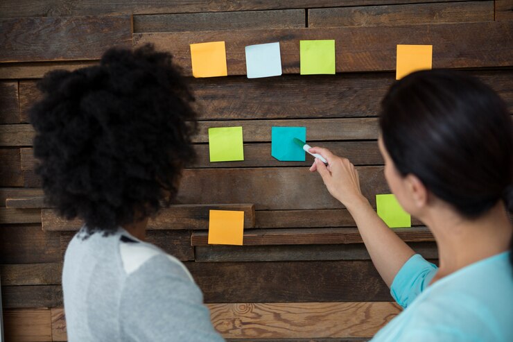 Photo female graphic designer pointing at sticky notes