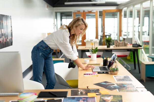 Foto designer grafica donna che usa un portatile alla scrivania