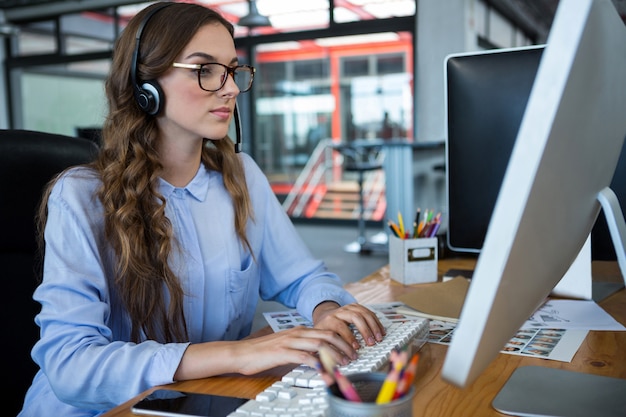 コンピューターのデスクで働く女性のグラフィックデザイナー