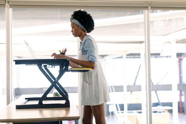 Female graphic designer working on laptop at desk