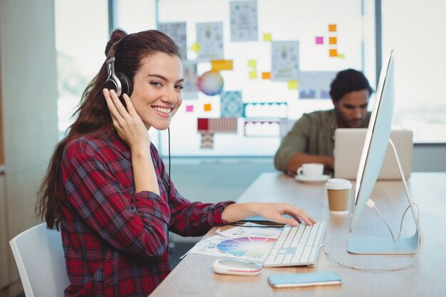 Female graphic designer working while listening music