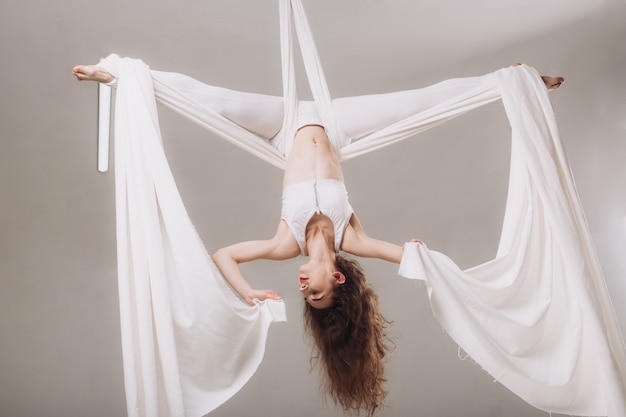 Гимнастка занимается воздушной шелковой акробатикой