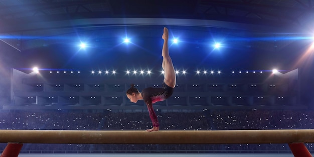 Female gymnast doing a complicated trick on gymnastics balance beam in a professional arena