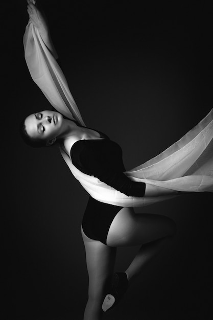 Female gymnast posing on a black background 