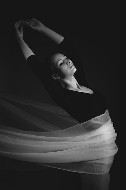 Female gymnast posing on a black background 