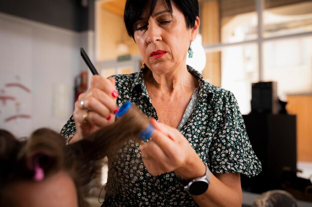 A female hairdresser curling her client's hair at the hair salon