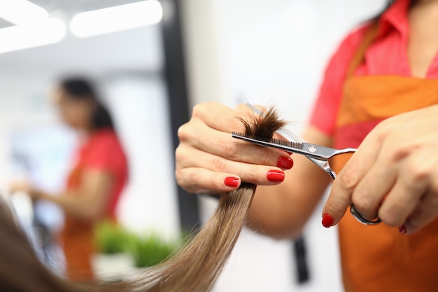 Female hairdresser hand hold strand of hair closeup