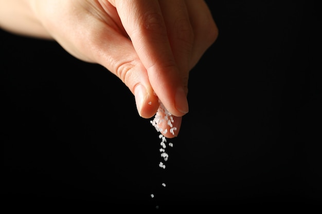 Female hand adding salt isolated