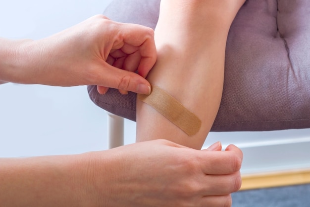 Female hand applying ointment on the bruise on leg of child. Pain, hematoma.