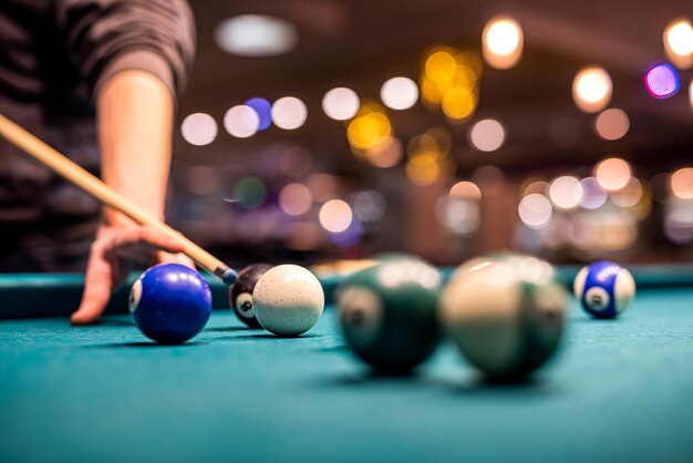 Female hand collects colored balls after playing billiards and prepares a new game