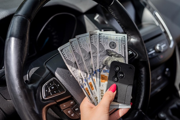 Female hand counting us dollar in a car