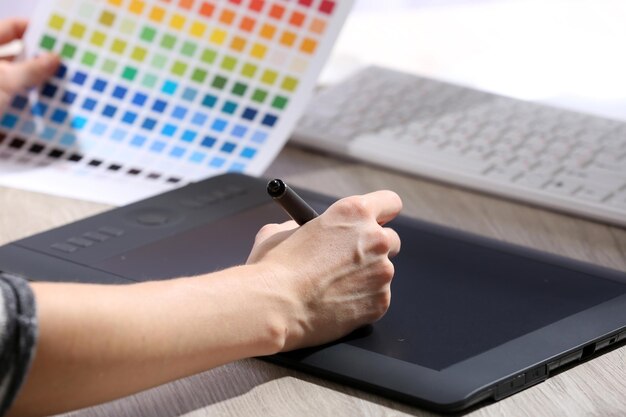 Женский ручной рисунок на графическом планшете в офисе крупным планом