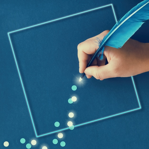 Foto traccia femminile del disegno della mano dei fiocchi di neve di carta dalla spoletta di piuma blu su carta blu scuro