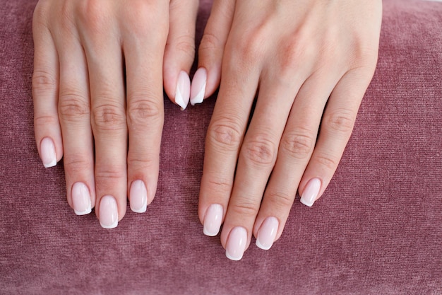 Female hand fingers nails with manicure after nail salon procedure