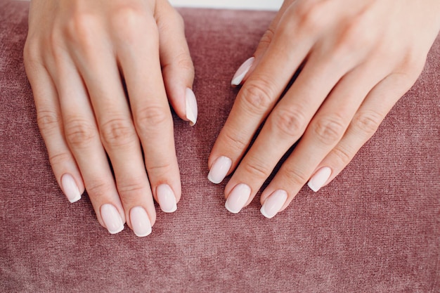 Female hand fingers nails with manicure after nail salon procedure