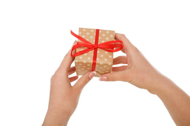 女性の手は、白い背景、クローズアップ、カットアウトで隔離の赤いリボンと紙にプレゼントを与える