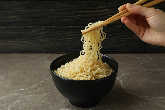 Female hand hold chopsticks with noodles