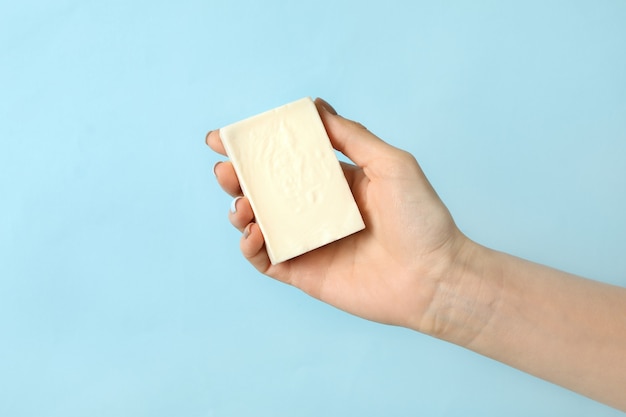 Photo female hand hold handmade soap on blue