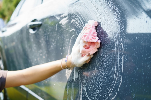 Female hand hold microfiber cloth for washing car. Concept disinfection and antiseptic cleaning