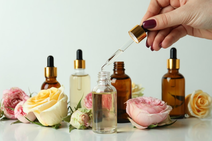 Photo female hand hold pipette with rose essential oil