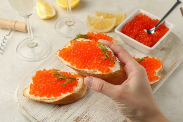 Female hand hold sandwich with red caviar