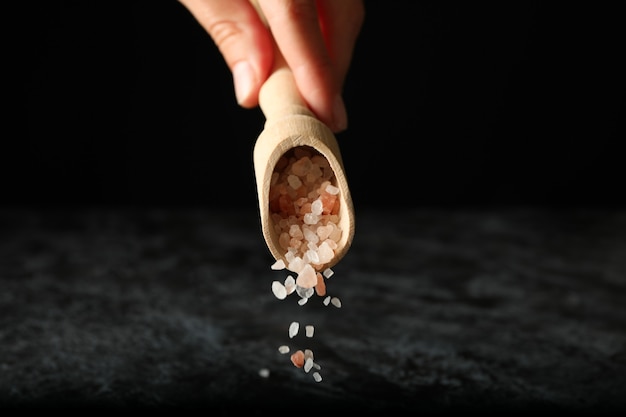 Female hand hold scoop with pink himalayan salt