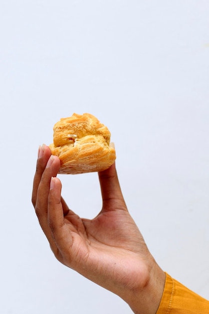 Photo female hand hold vanilla custard soes choux