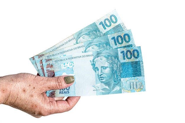 female hand holding 100 reais bank notes, concept of retirement or government aid