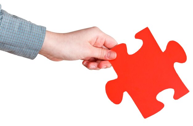 Female hand holding big red paper puzzle piece