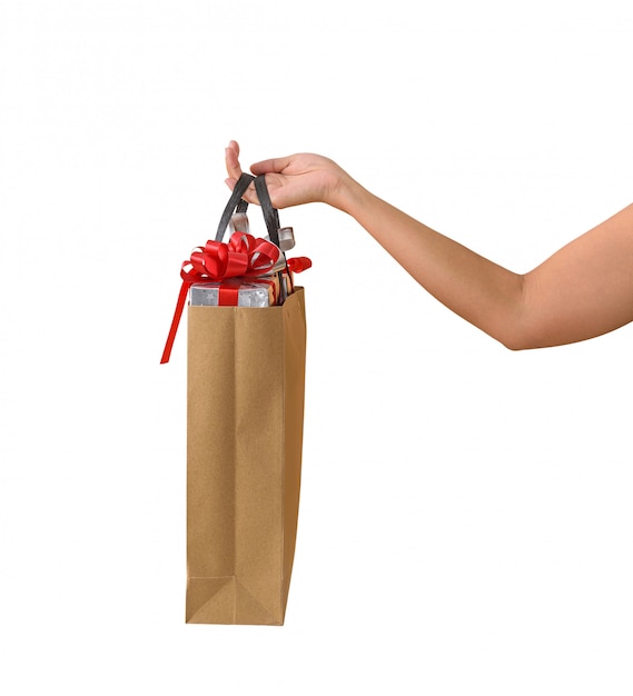 Mano femminile che giudica i sacchetti della spesa marroni in bianco marroni in pieno dei contenitori di regalo ornati
