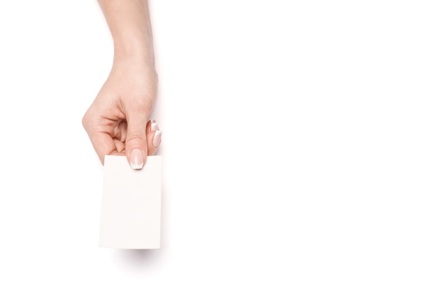 Female hand holding a blank business card over white surface