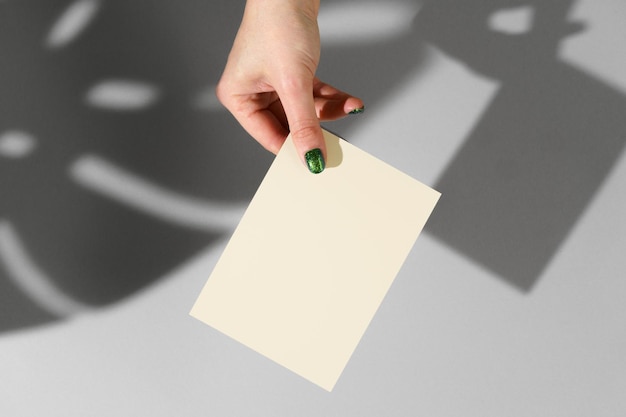 Female hand holding blank businesscard creative photo with shadow
