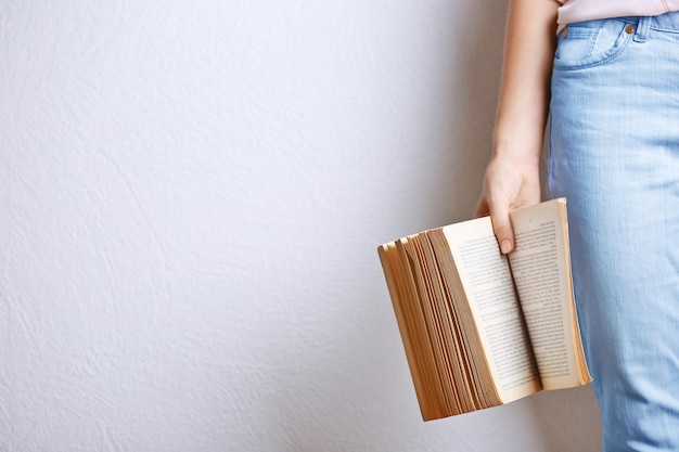 Женская рука держит книгу на светлом фоне